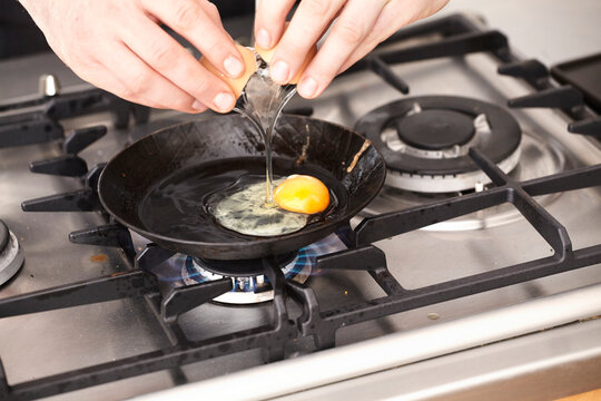Close-up of man preparing fried egg