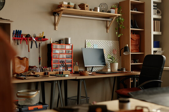 Empty artisan workshop desk with computer and crafting tools