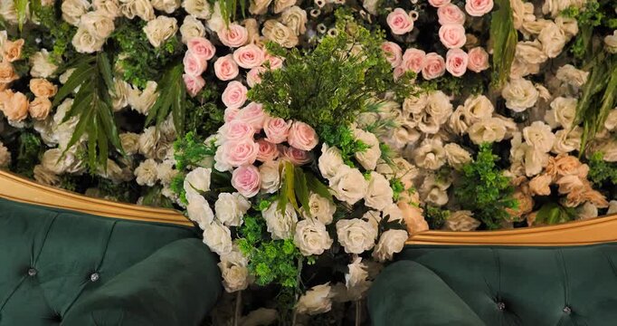 Pink and white rose floral wall backdrop with a green velvet sofa for wedding event decor