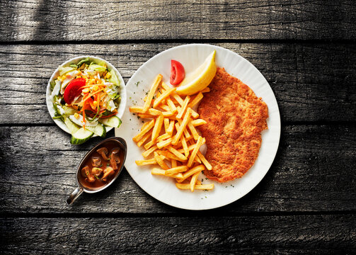 Jagerschnitzel meal with mushroom sauce on a dark wooden table