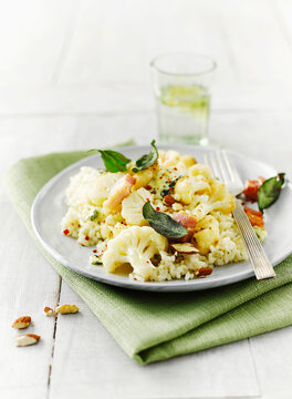 A plate of almond rice with cauliflower and sage sits on a table