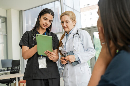 Female doctor and nurse look at a tablet in the hospital