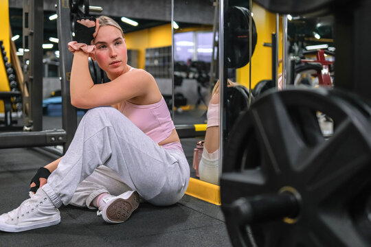 Athlete resting after weightlifting during gym workout indoors