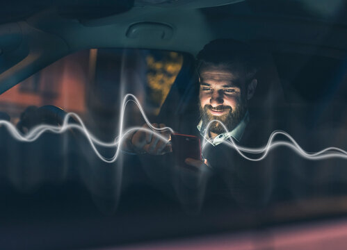 Man uses mobile chatbot in car at night