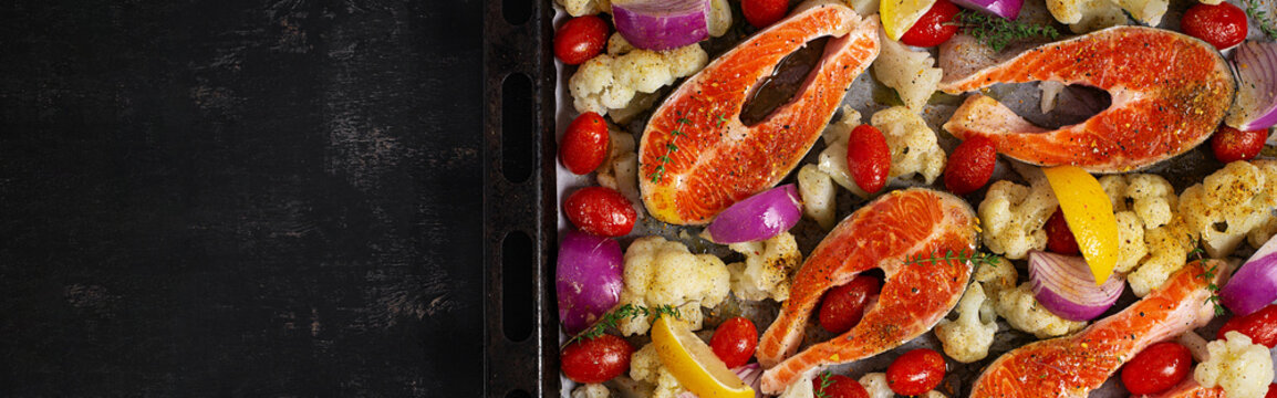 Raw Salmon with Cauliflower and Tomatoes Ready for Roasting. Top view, banner