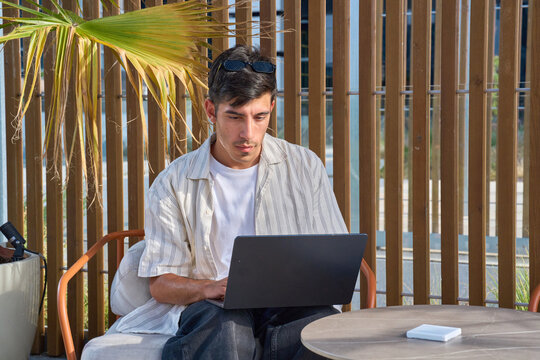 Man working remotely outdoors using laptop technology