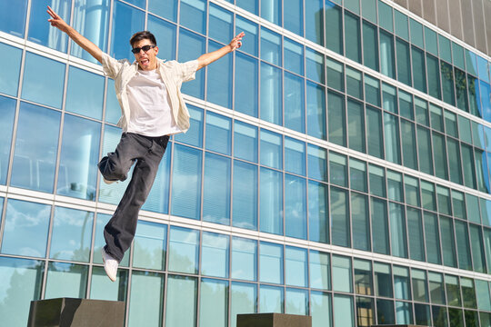Young man jumping expressing happiness and freedom outdoors
