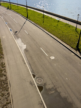 Empty asphalt path beside calm water