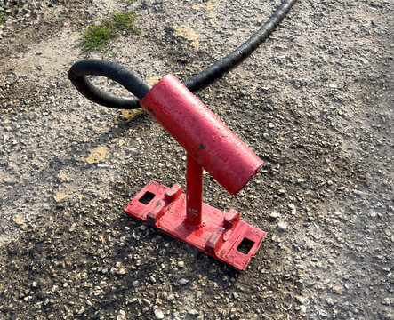 Red metal bracket with black cable attached