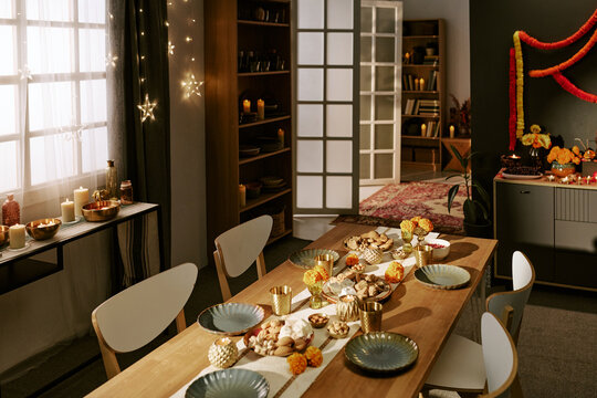 High angle view of decorated dining table prepared for Diwali festival celebration at home. Scene suitable for holiday marketing and cultural advertising