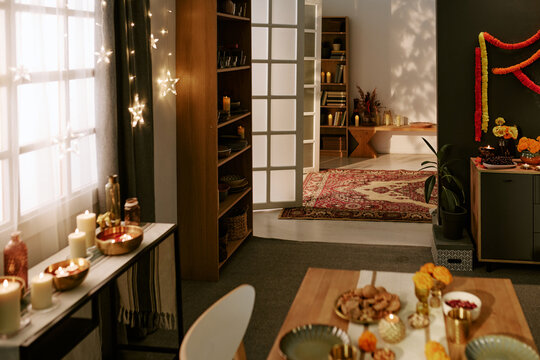 Festive interior decorated with candles, marigold garlands, and tableware for cultural holiday celebration. Concept suitable for festive marketing campaigns and event promotions