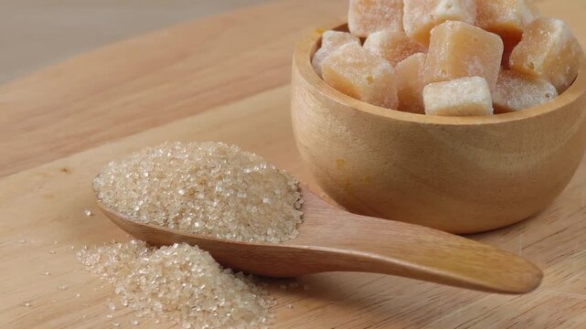 Brown sugar cubes in a bowl, granulated brown sugar in a spoon