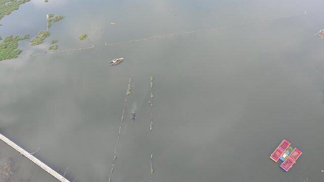 Beautiful aerial drone view of the Blue Bridge (Jembatan Biru Sumurup) at Rawa Pening lake with local village houses in Semarang, Central Java, Indonesia.