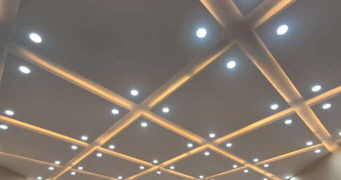 Modern false ceiling design with recessed LED spotlights and warm ambient cove lighting