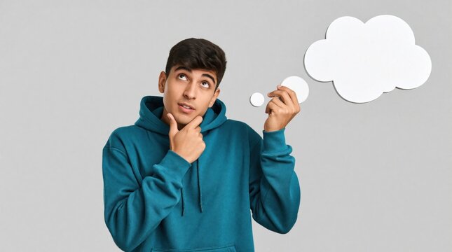 Young man in teal hoodie thinks deeply. Male person looks up with pensive face, holding blank white thought bubble. Creative guy brainstorms new ideas, solves problems plans future strategy in