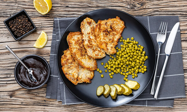 batter fried pork cutlets on a black plate