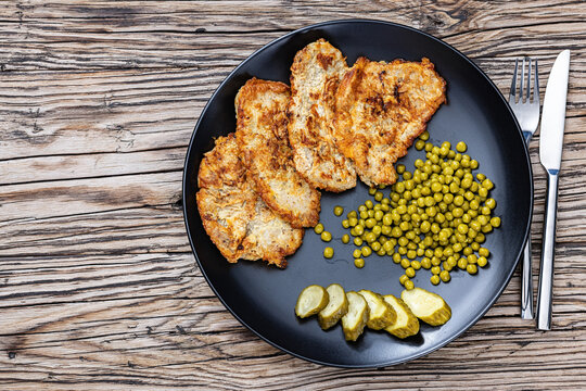 Pork cutlets in egg batter with canned green peas