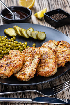 Pork cutlets in egg batter with canned green peas