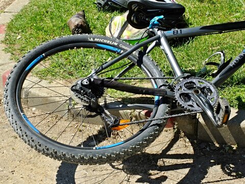 Mountain bicycle wheel and pedal detail on grass