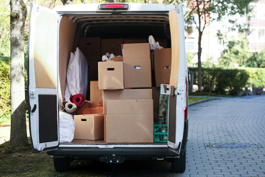 Ge&ouml;ffneter wei&szlig;er Transporter vollgepackt mit Umzugskartons, Teppichrollen und M&ouml;beln. Umzug, Logistik, Transport, Lieferwagen.