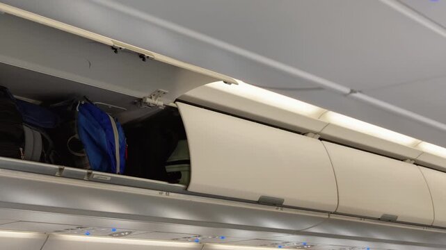 Open overhead luggage compartment in passenger airplane cabin