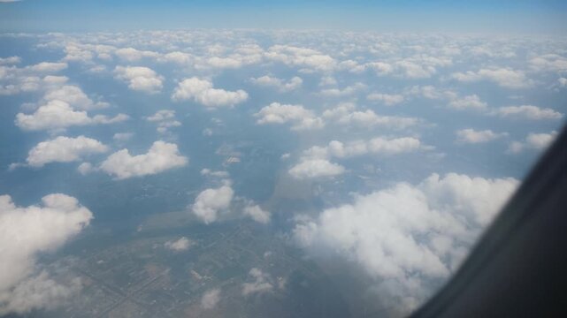 Aerial view of land and clouds from aircraft