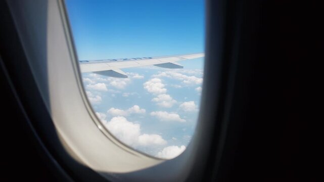 Passenger holding water bottle beside airplane window