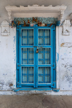 Blue door decorated with dried flowers, Mandvi, India