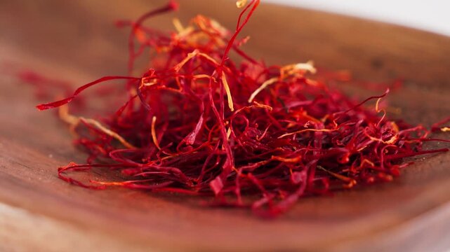 Close up of premium saffron threads on a wooden surface. Luxury aromatic spice used in Mediterranean, Middle Eastern, and Asian cuisine for gourmet cooking and traditional recipes.