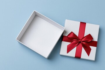 Obraz premium The Gift Box with Red Ribbon on Pale Blue Studio Background