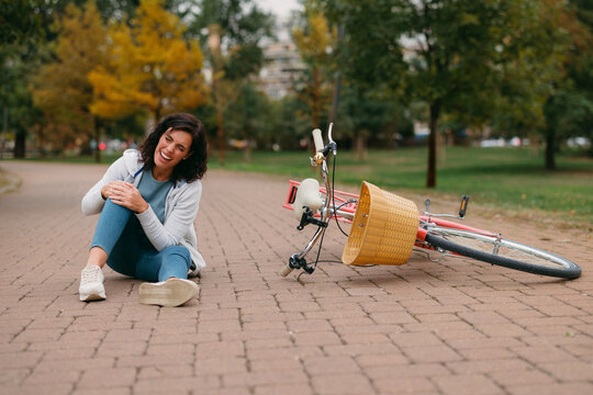 Woman experiencing knee pain after bicycle accident fall