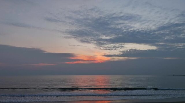 A nature sky panoramic scenic view of a vibrant sunset or sunrise sky with glowing orange and yellow clouds transitioning into deep blue twilight, representing nature beauty, and tranquility at ocean