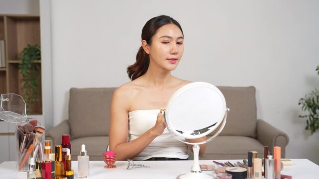 Asian beauty influencer recording makeup tutorial at home, skincare and cosmetics content creator livestream.