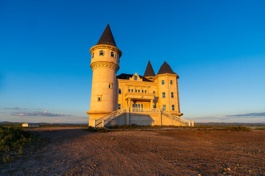 Isolated Castle with Wind Turbines at Sunset