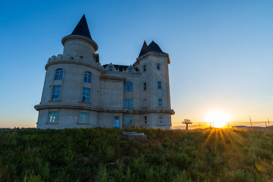 Isolated Castle with Wind Turbines at Sunset