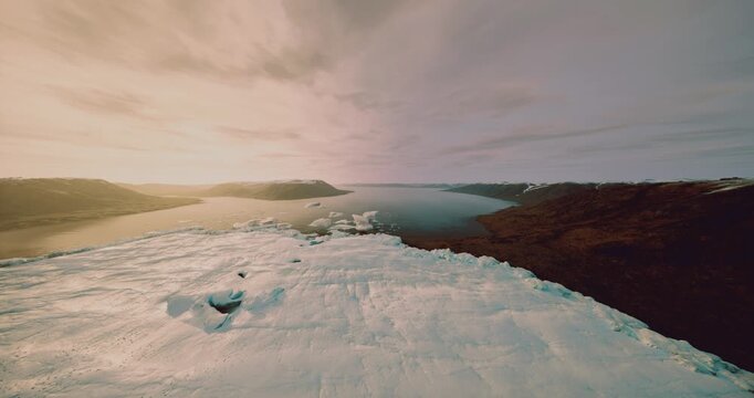 aerial view of glacier frame for timelapse monitoring, scattered ice floes and reflective channel, visual suited for longitudinal study, data capture