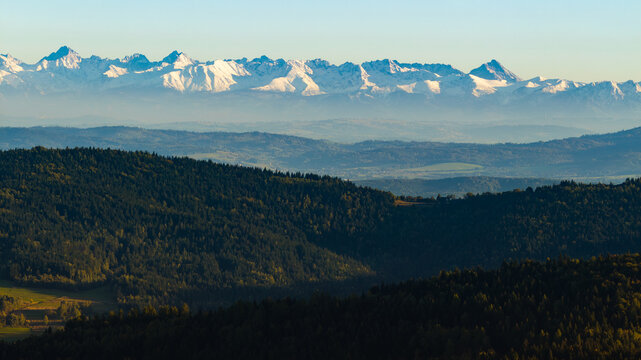 Tatra Mountains on the horizon above rolling hills in Poland, aerial view