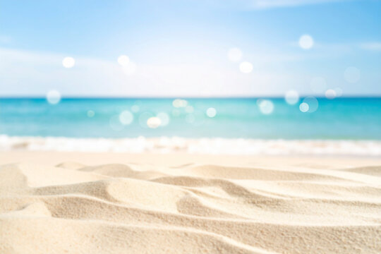 Blurred summer background. defocused beach sand in the foreground and sea in the background.