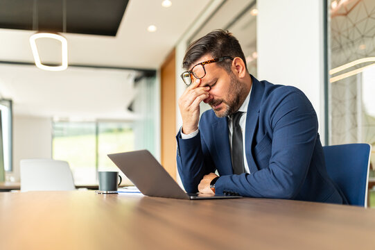 Professional experiencing intense headache and burnout from work pressure and stress. Suffering from mental exhaustion during a challenging office task