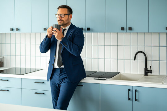 Business professional enjoying a refreshing coffee break in the contemporary office kitchen, taking a moment of pause during a busy corporate workday