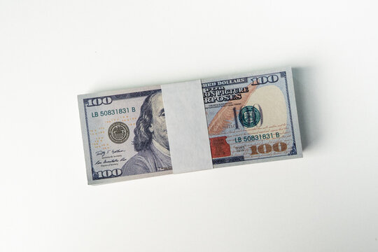Wrapped stack of hundred dollar bills with a paper band on a white background