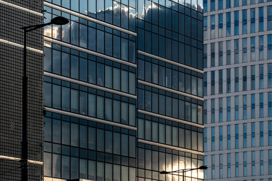 Office facade with glass windows and grid architecture in Wola financial district, Warsaw, Poland showing reflections across the frame.