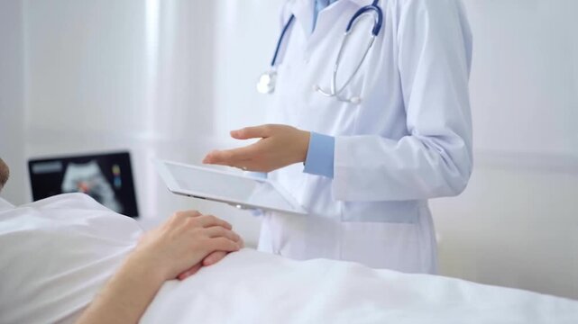 Doctor consulting patient with digital tablet in hospital room. Healthcare professional providing care