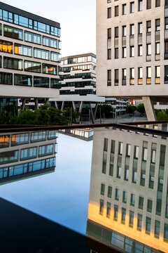 Modern buildings use reflection and geometry to create symmetry in architecture in Vienna, Austria, forming an urban composition across the frame.