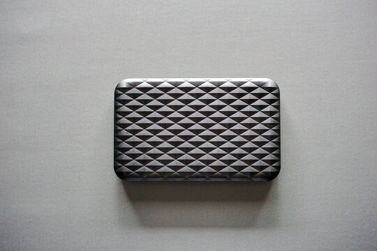 Top view of a modern portable external hard disk drive on a grey background.