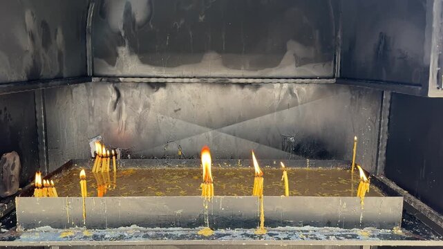 Orthodox Christian tradition of lighting candles at monasteries and churches in the Balkans, symbolizing prayer and remembrance in a peaceful sacred religious setting.