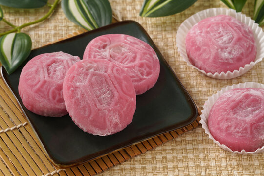 Traditional pink red turtle rice cake on woven grass mat background.