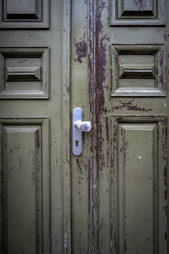 Weathered Green Wooden Double Door with Peeling Paint and Silver Handle
