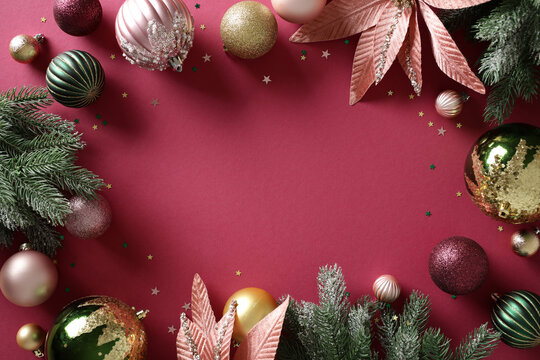 Christmas background with baubles and fir branches on burgundy table