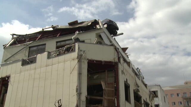 Cars And Debris Rest On Roof Of Tall Building In Aftermath Of Tsunami In Japan